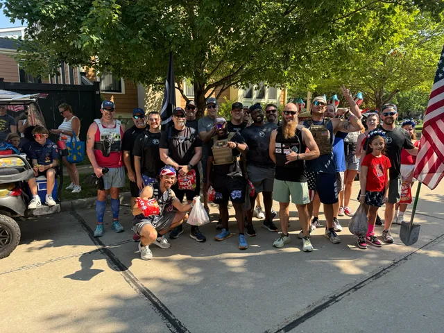 Large group of men in black shirts and weighted vests poses on a sunny street with kids, an American flag and a golf cart.