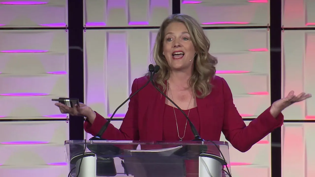 Economist Tawni Hunt Ferrarini speaking at a podium during a keynote presentation