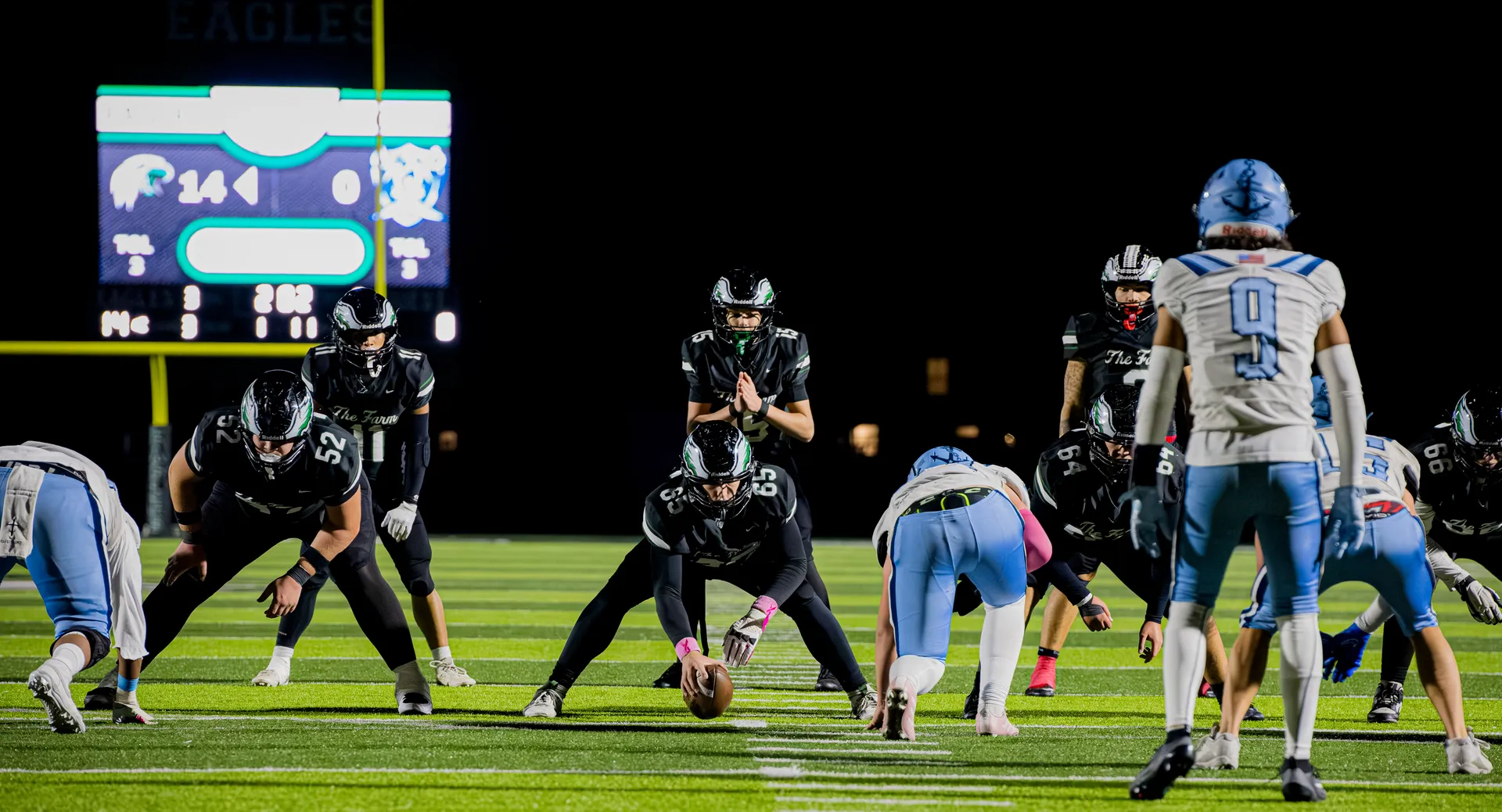 Orchard Farm Eagles line up on offense under the lights during a Friday night game
