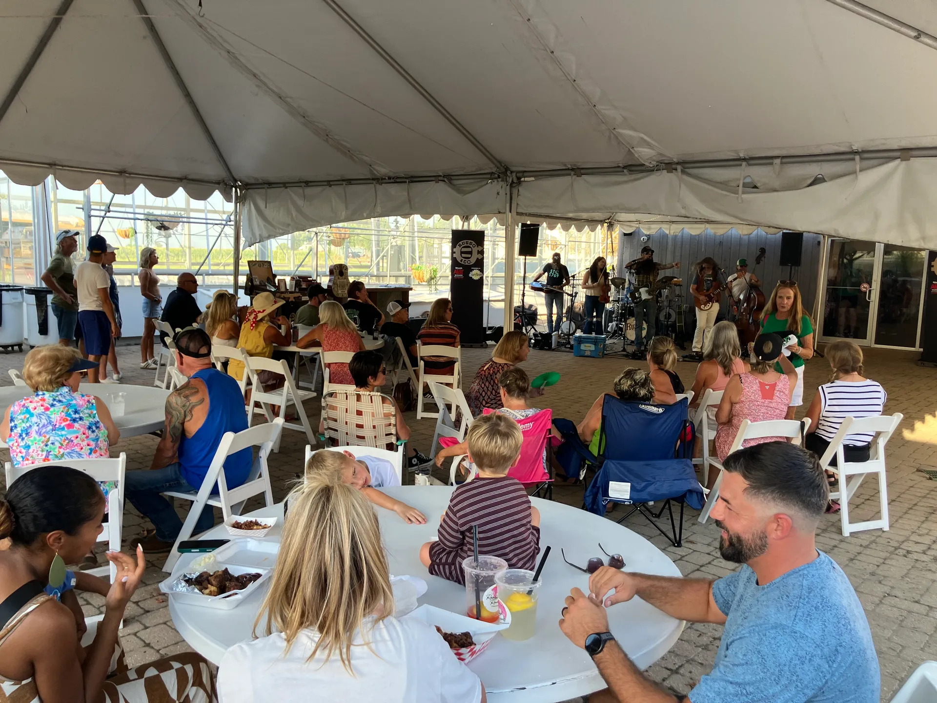 Community members gathered under the tent watching Russo & Co.