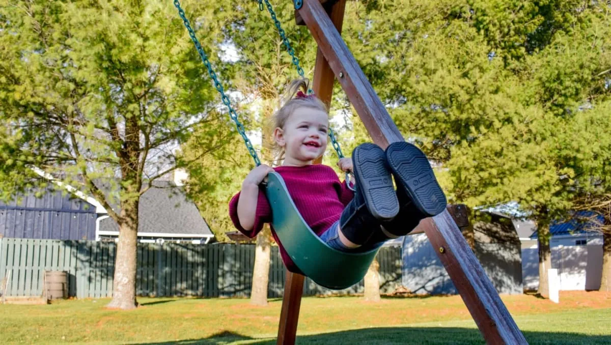 Braxley, 3, smiling on a swing — competitors race in her honor to fund MSMDS research