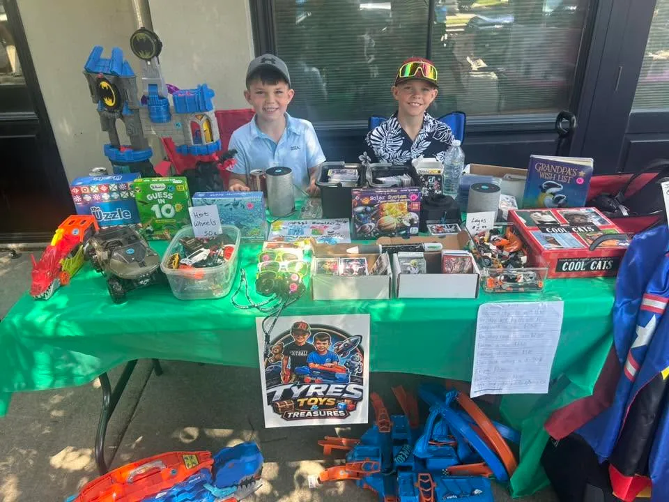 Two young vendors sell toys, games and Hot Wheels at their Tyres Toys & Treasures table