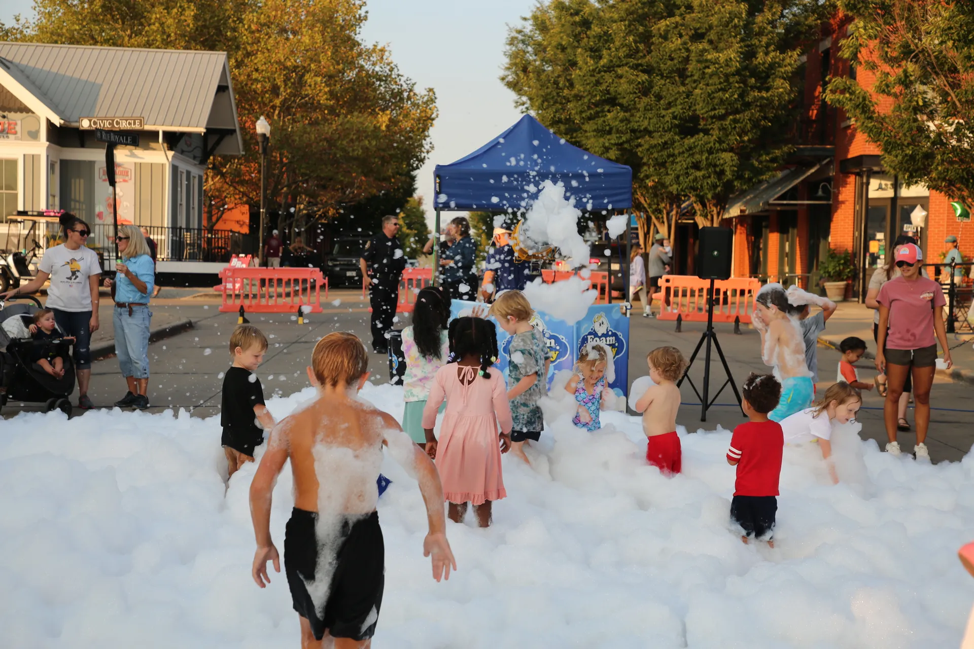 Kids playing in foam from the bubble truck at St. Charles Night Out in New Town
