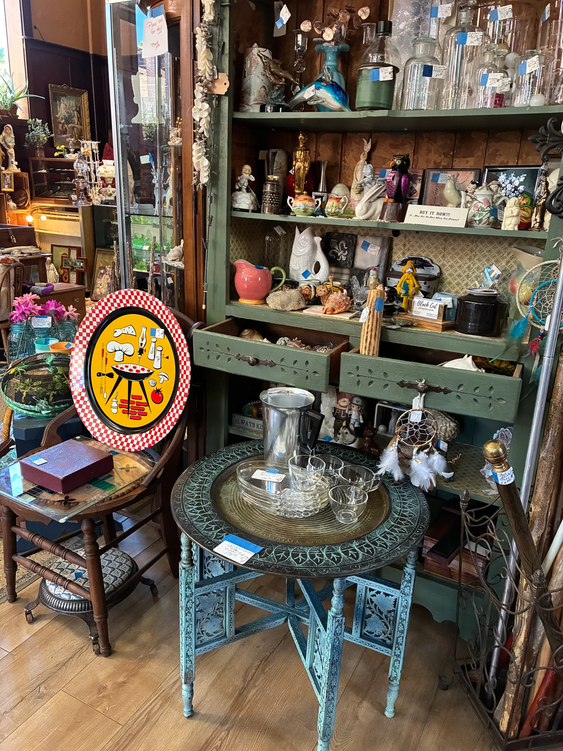 Eclectic mix of vintage glassware, figurines and furniture displayed inside Black Cat Antiques and Such