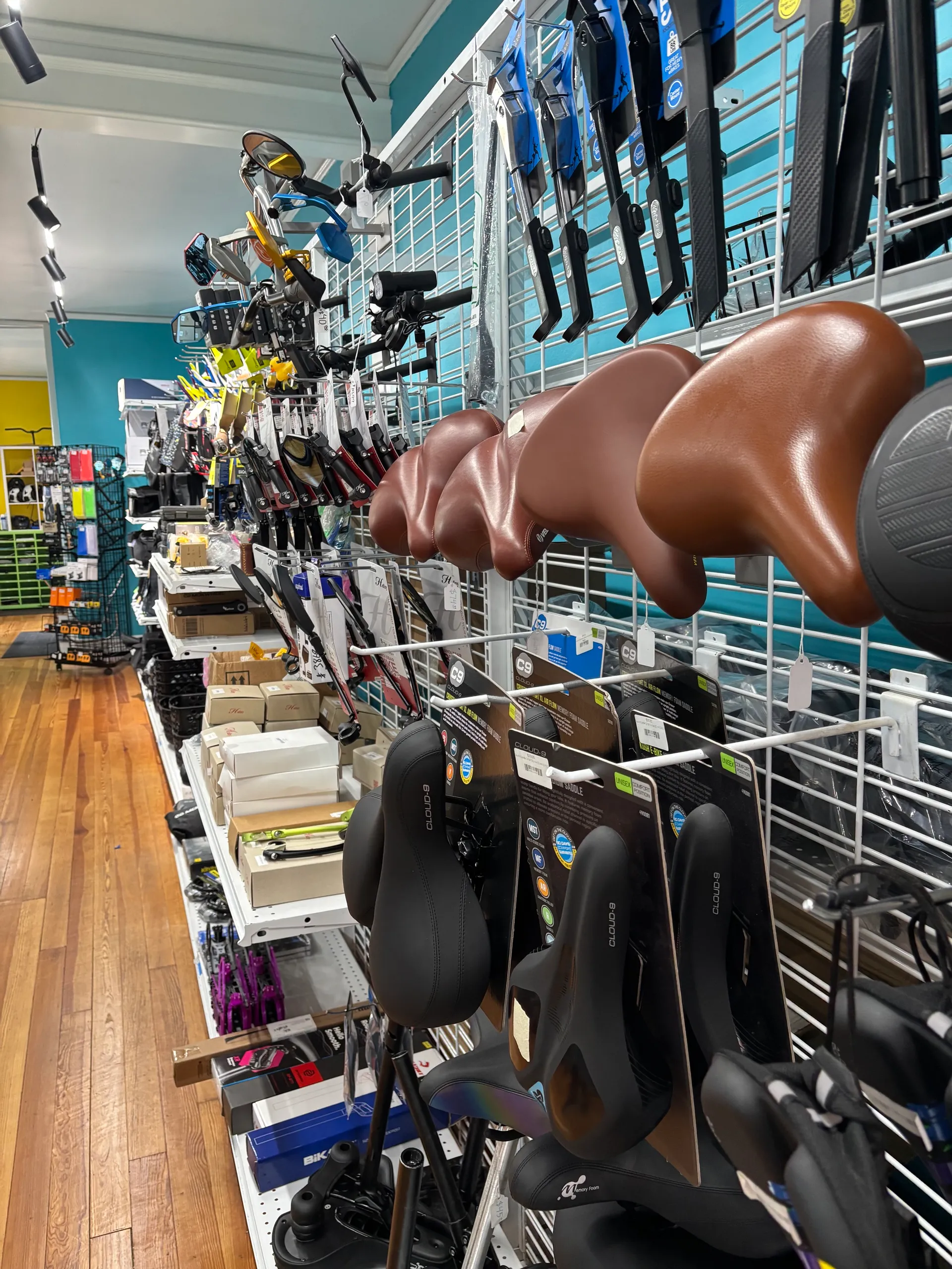 Wall of e-bike accessories including helmets, mirrors, and grips at Juiced Wheels