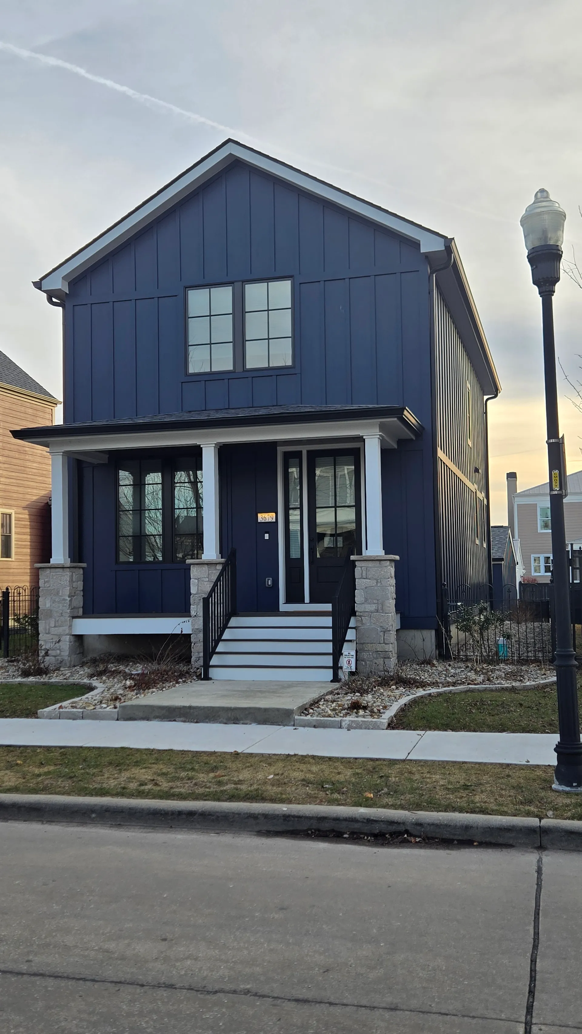 Navy blue board-and-batten siding on a two-story New Town home
