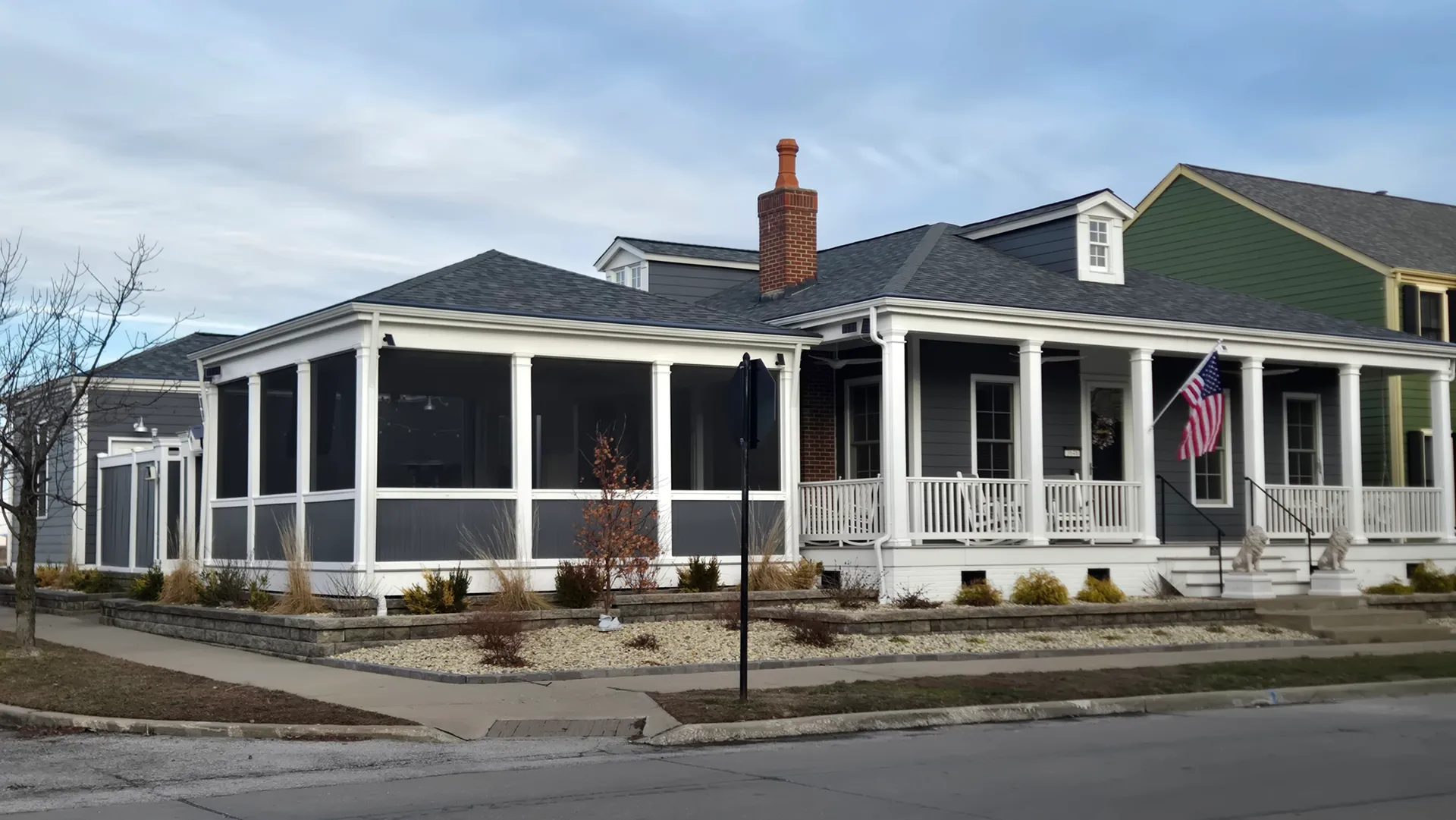 Corner view of a gray-sided New Town home with screened porch and front porch