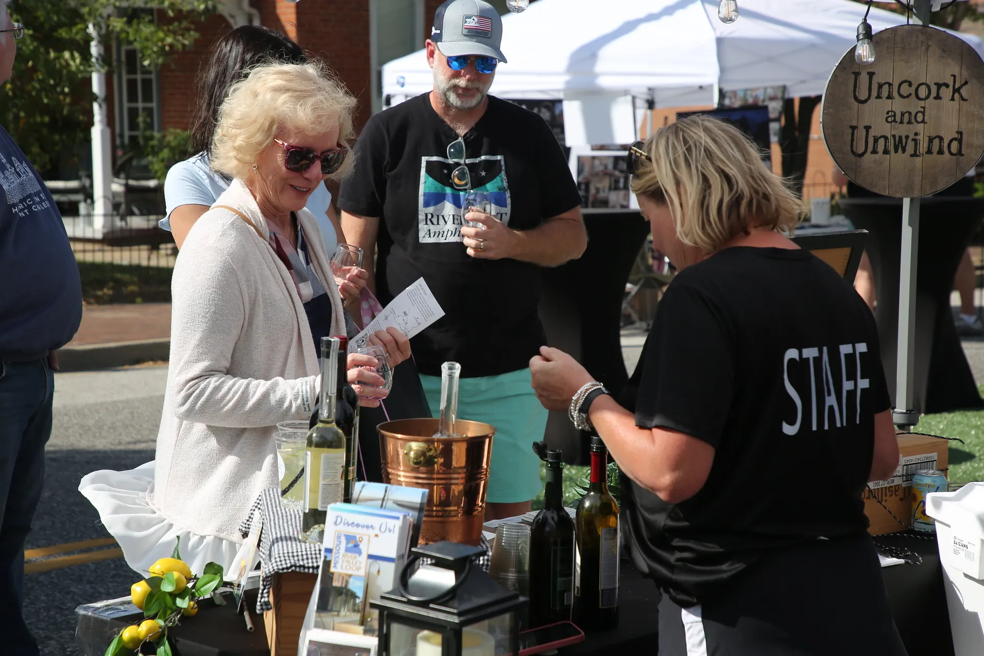 Guests sample wine at a tasting booth during La Fête du Vin