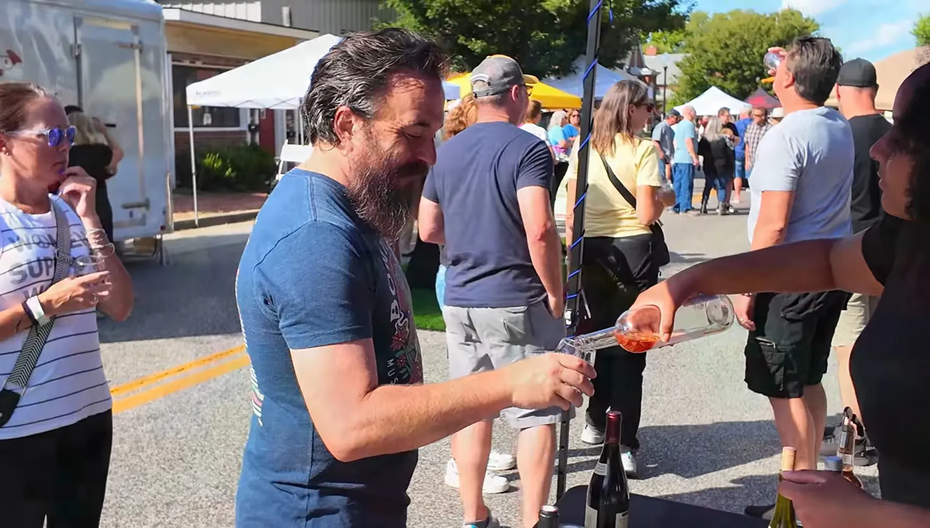 A vendor pours a wine sample for an attendee along North Second Street at the festival