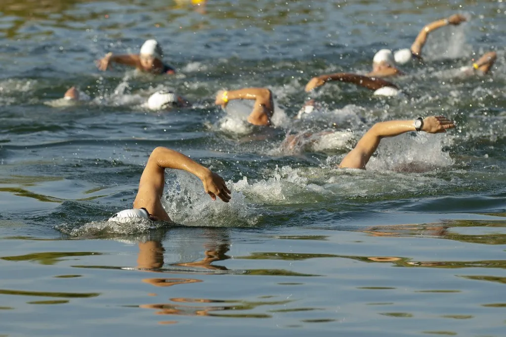 Swimmers racing through open water during the triathlon swim leg