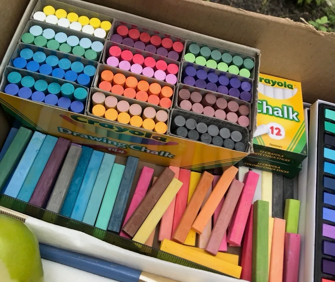 A box filled with colorful sticks of drawing chalk and pastels for Chalk the Walk artists