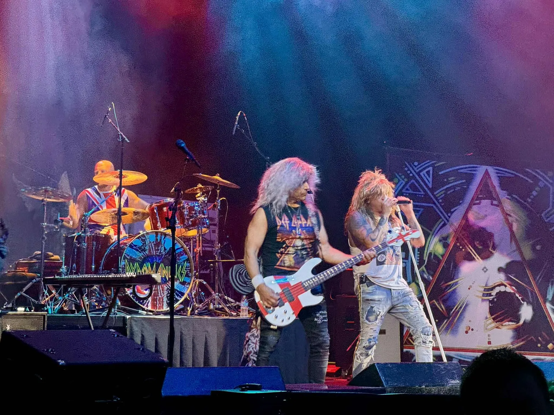 Pyromaniacs bassist and singer performing Def Leppard hits under stage lights