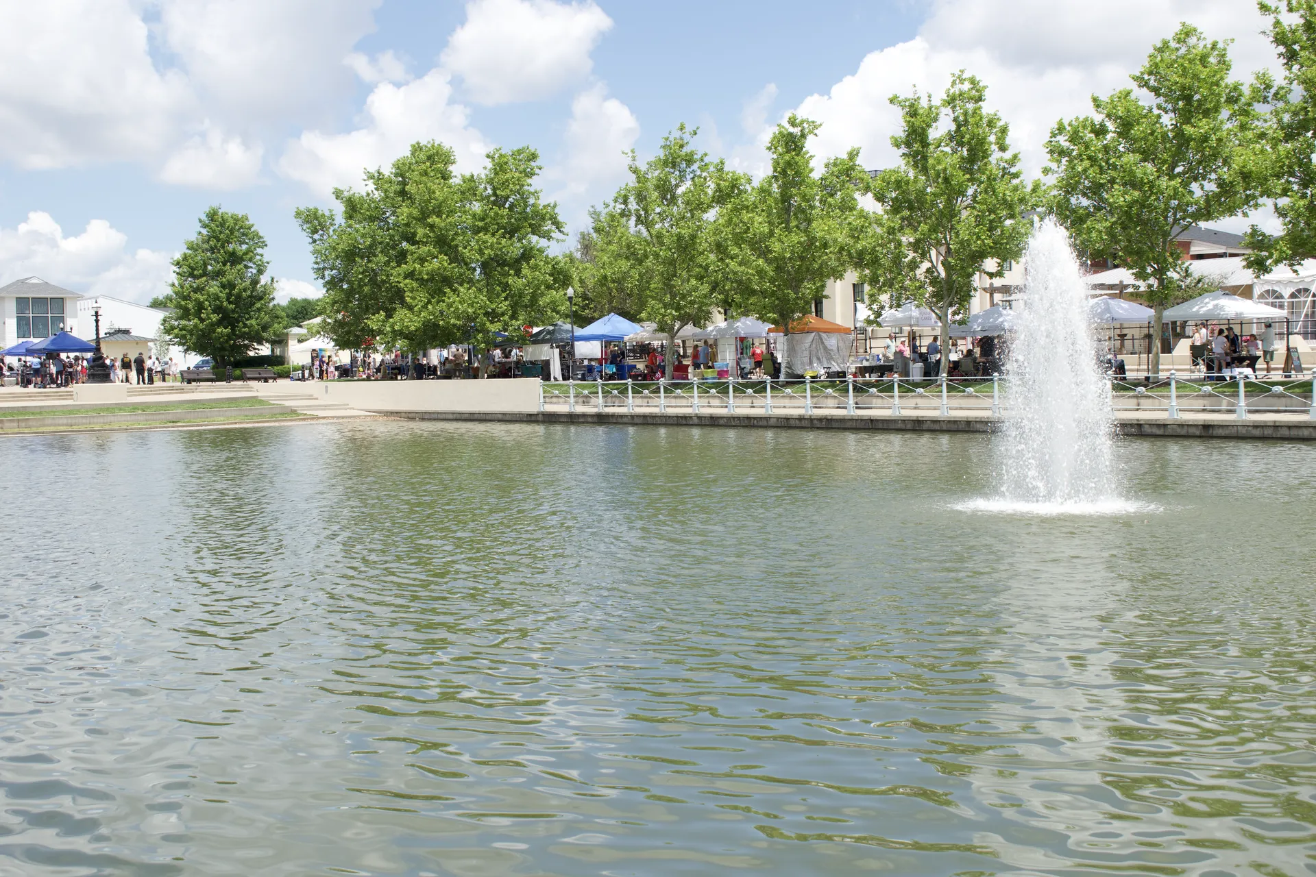 Market tents line the waterfront near the fountain on the Grand Canal in New Town at St. Charles