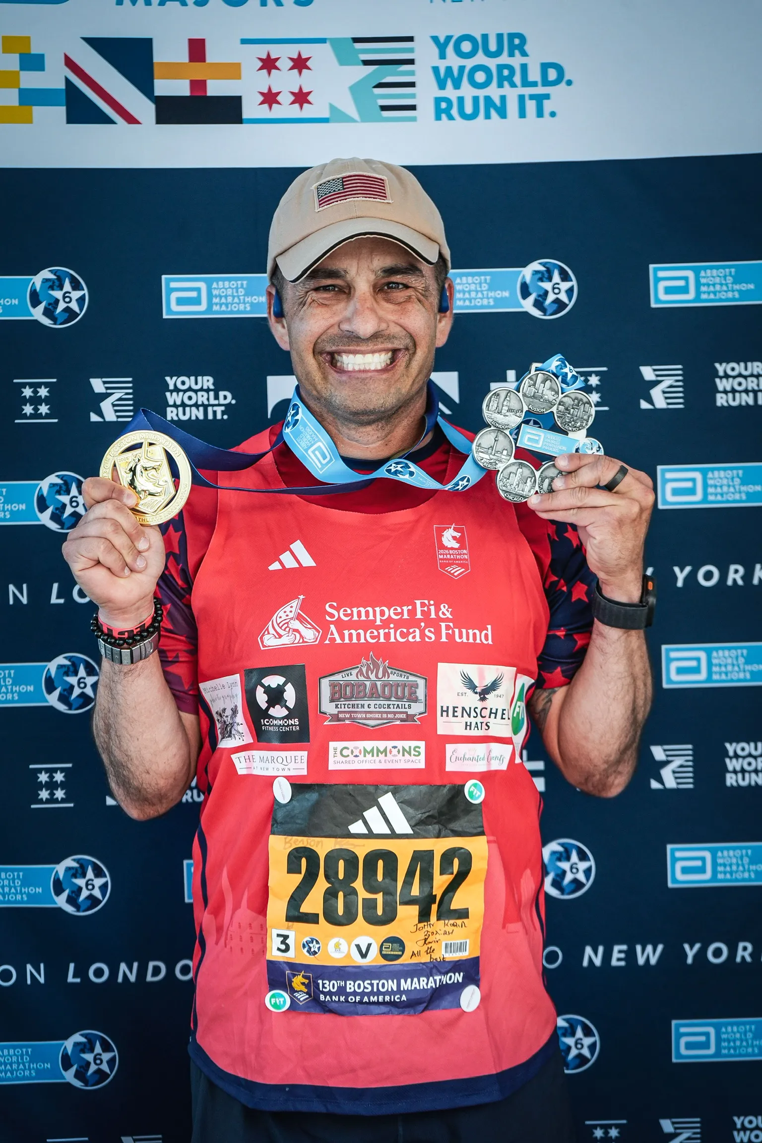 Paul Rosell smiling with his Boston Marathon medal and Abbott World Marathon Majors Six Star Medal